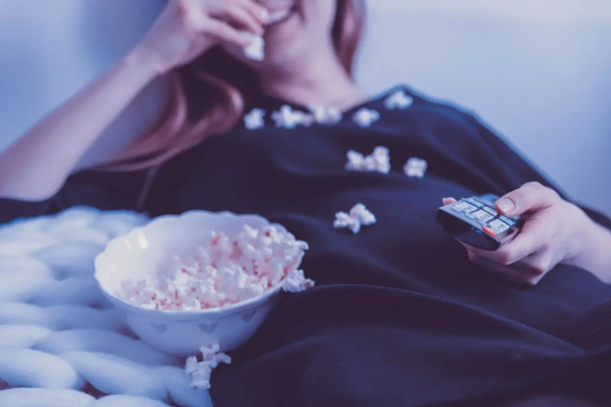 Woman watching TV with popcorn